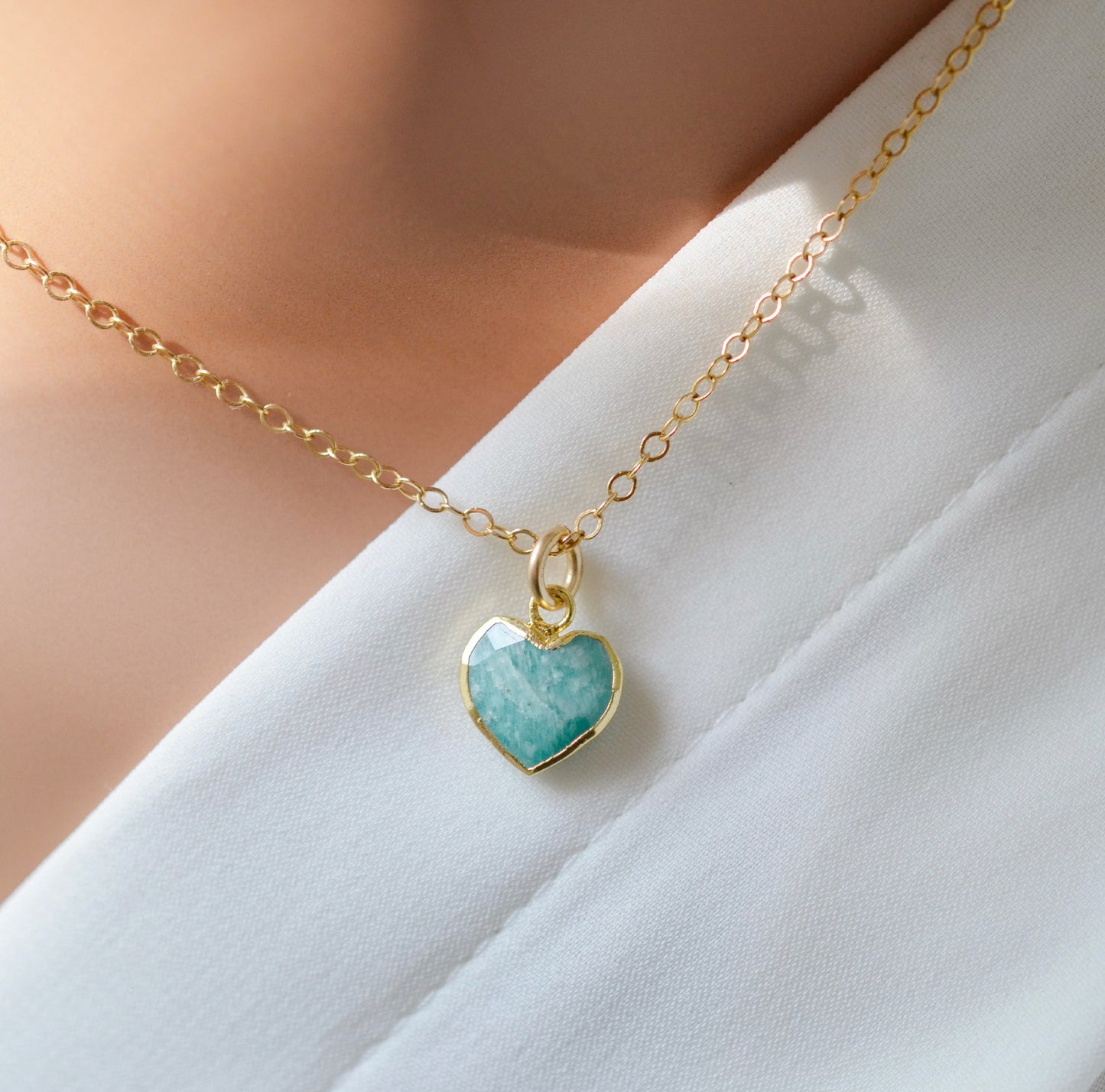 Natural blue green Amazonite gemstone pendant set on a 14k gold filled chain. The stone is a faceted heart shape and bezeled in 22k gold electroplate.