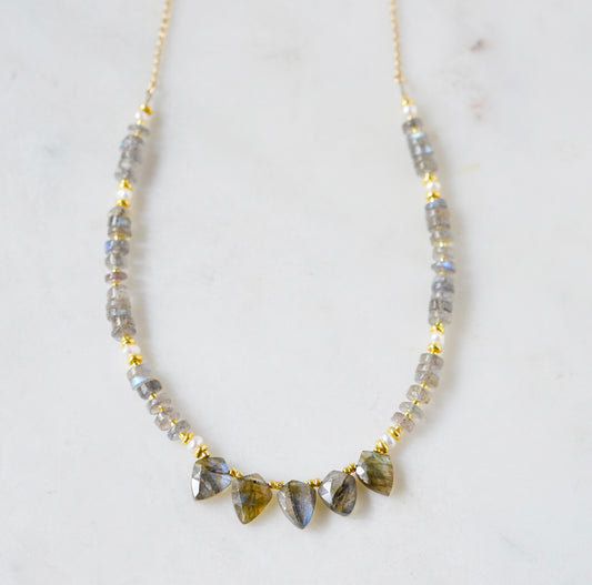 A handmade, beaded labradorite and pearl gemstone necklace with five labradorite teardrops in the front. Shown in 14k gold filled.