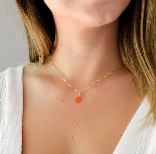 Modeled image. A delicate, genuine orange Carnelian gemstone teardrop pendant suspended from a 14k gold filled cable chain. This necklace is handmade and also comes in sterling silver.