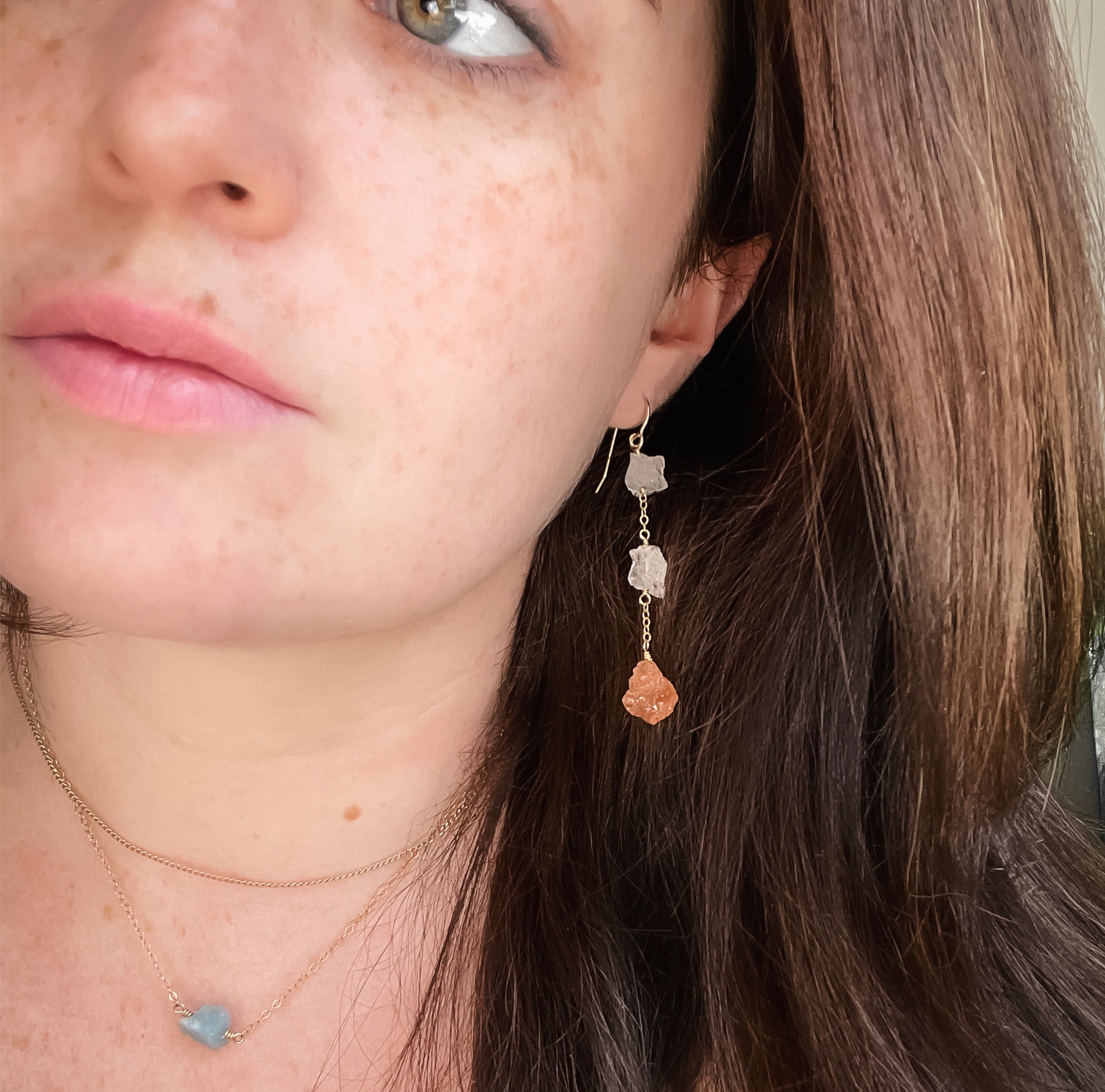 Rough clear quartz crystal and sunstone earrings modeled in gold.