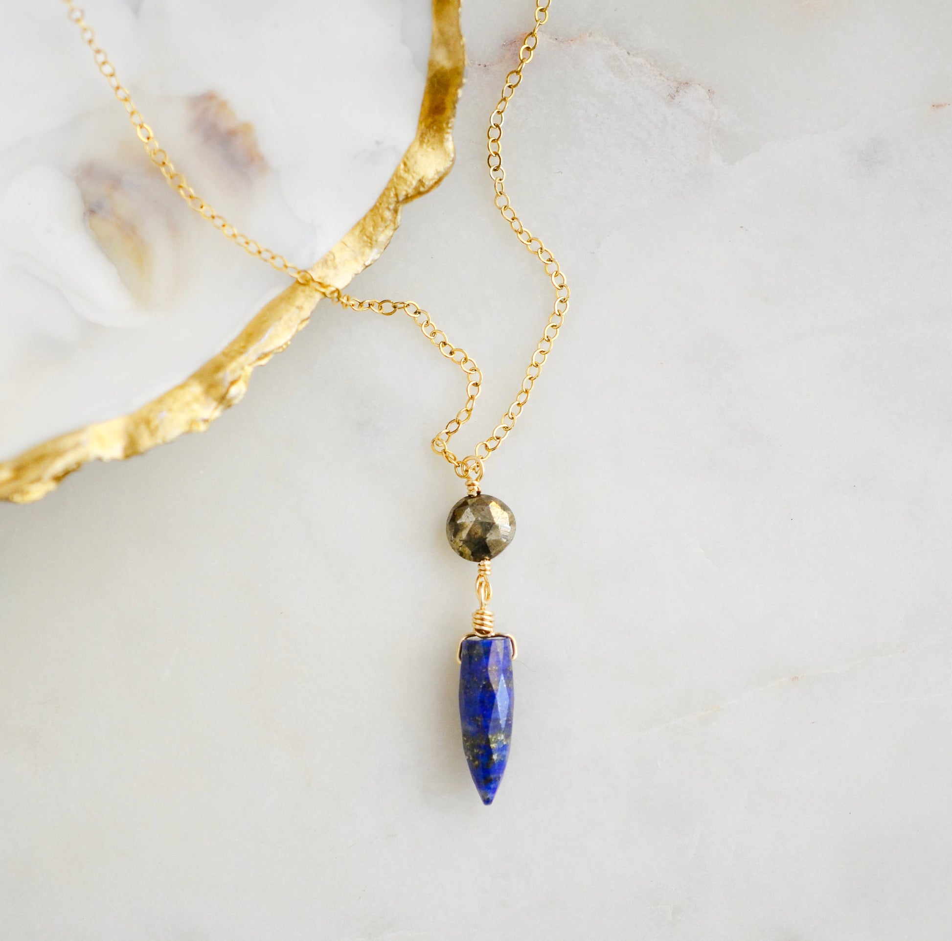 This necklace is handmade with natural pyrite and lapis lazuli suspended from a 14k gold filled or sterling silver chain.
