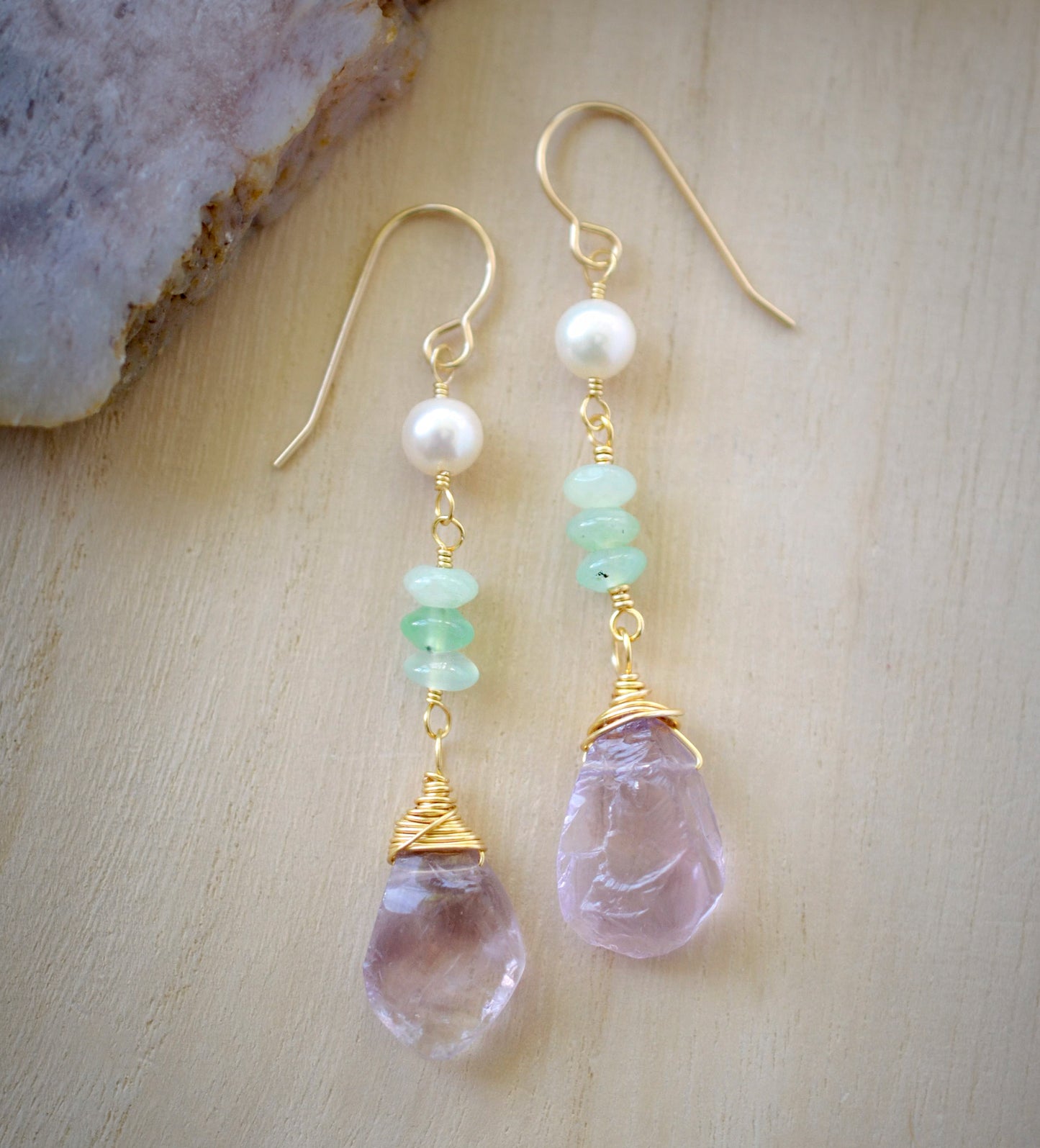 Detail image. Raw pale purple Amethyst gemstones dangle below three green chrysoprase stones and a single freshwater pearl. Shown in 14k gold filled.