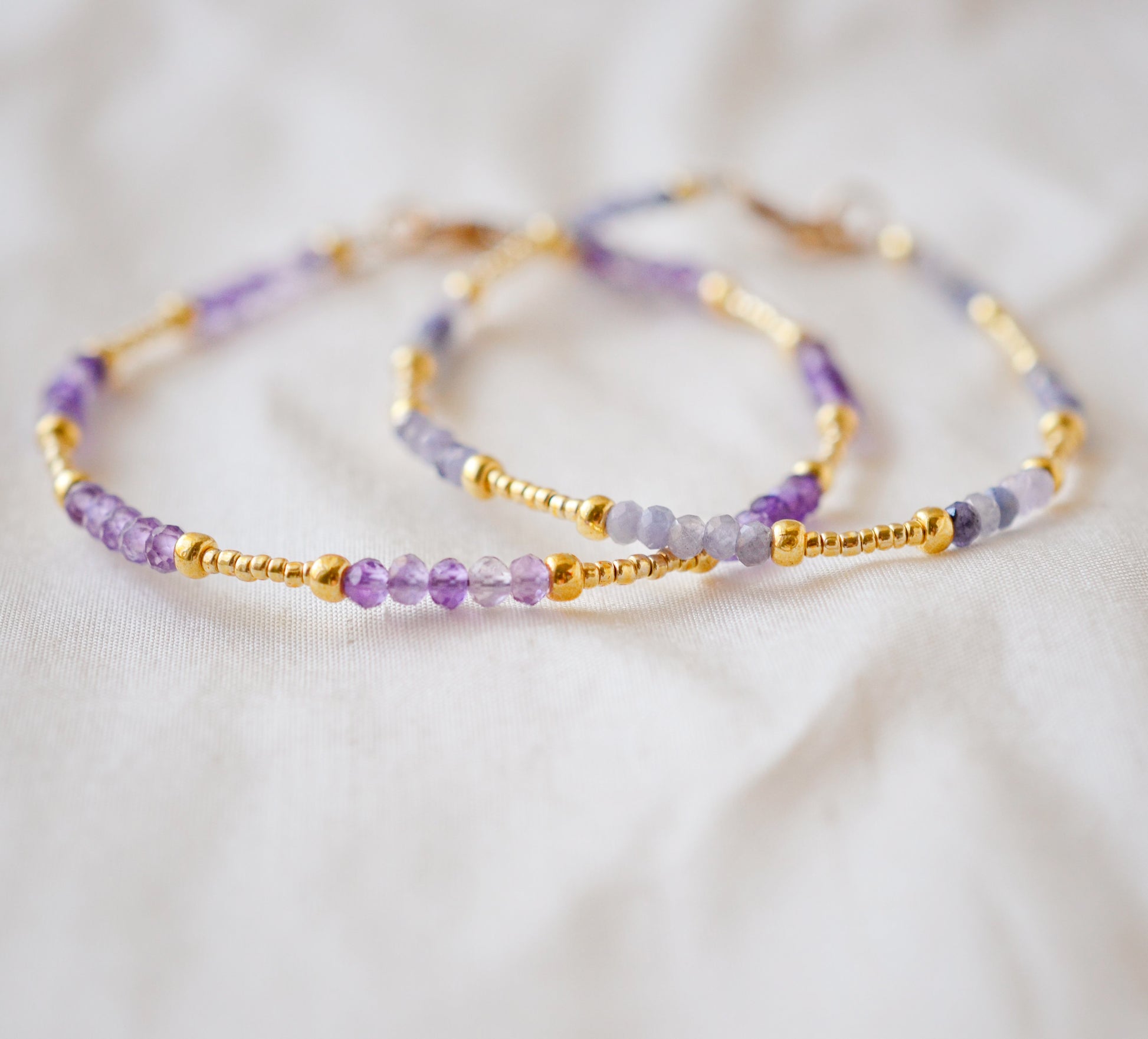 Handmade beaded gemstone crystal bracelet in gold filled or sterling silver. These bracelets feature a gemstone of your choice on a bracelet that can be stacked with others or worn alone. Modeled image showing: tanzanite, amethyst