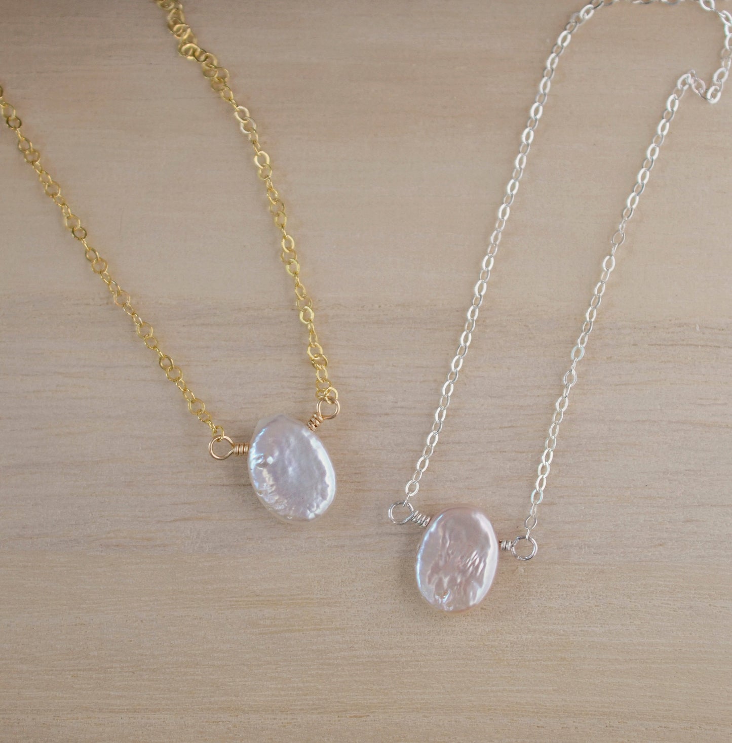 Single white oval shaped freshwater pearl suspended from a sterling silver or 14k gold filled cable chain.