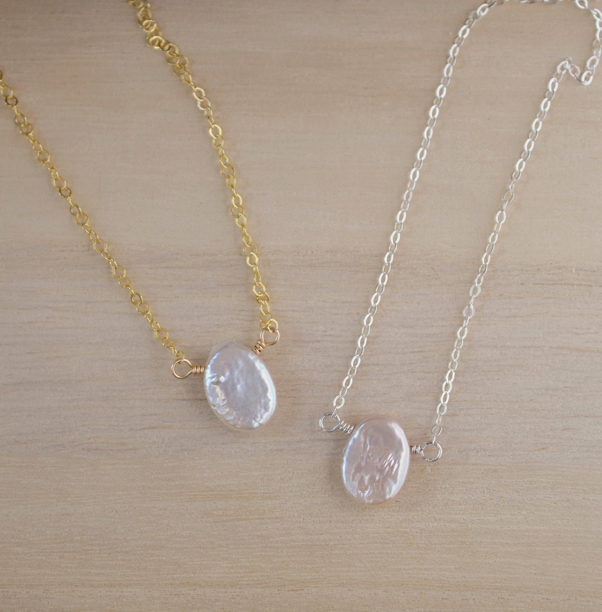 Single white oval shaped freshwater pearl suspended from a sterling silver or 14k gold filled cable chain.