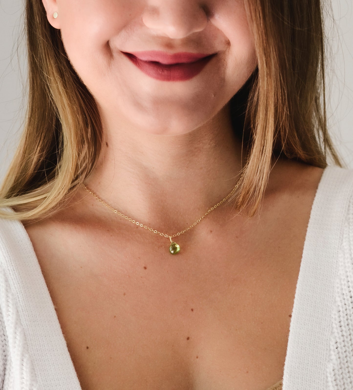 Natural green Peridot faceted teardrop suspended from a 14k gold filled cable chain. Modeled image.