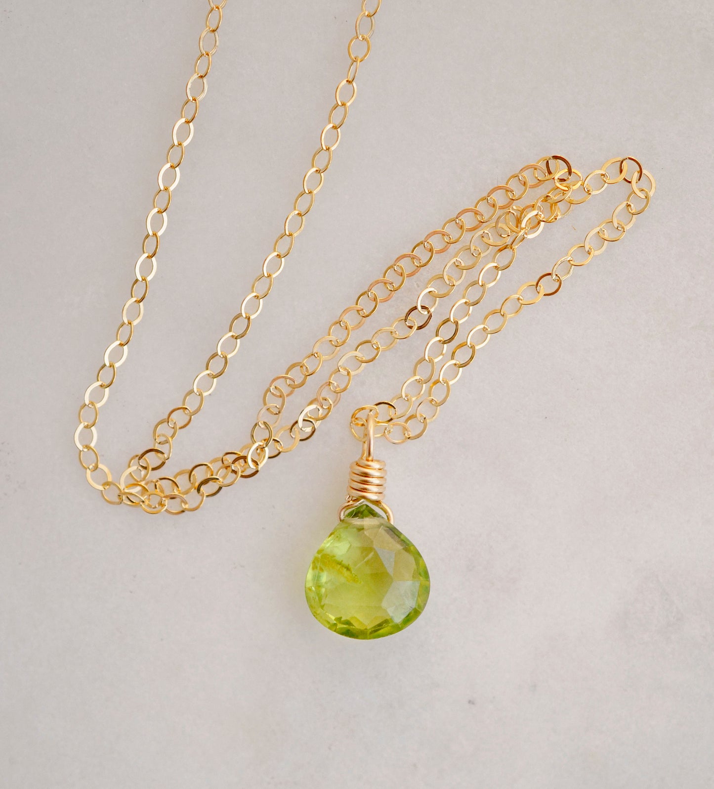 Natural green Peridot faceted teardrop suspended from a 14k gold filled cable chain.