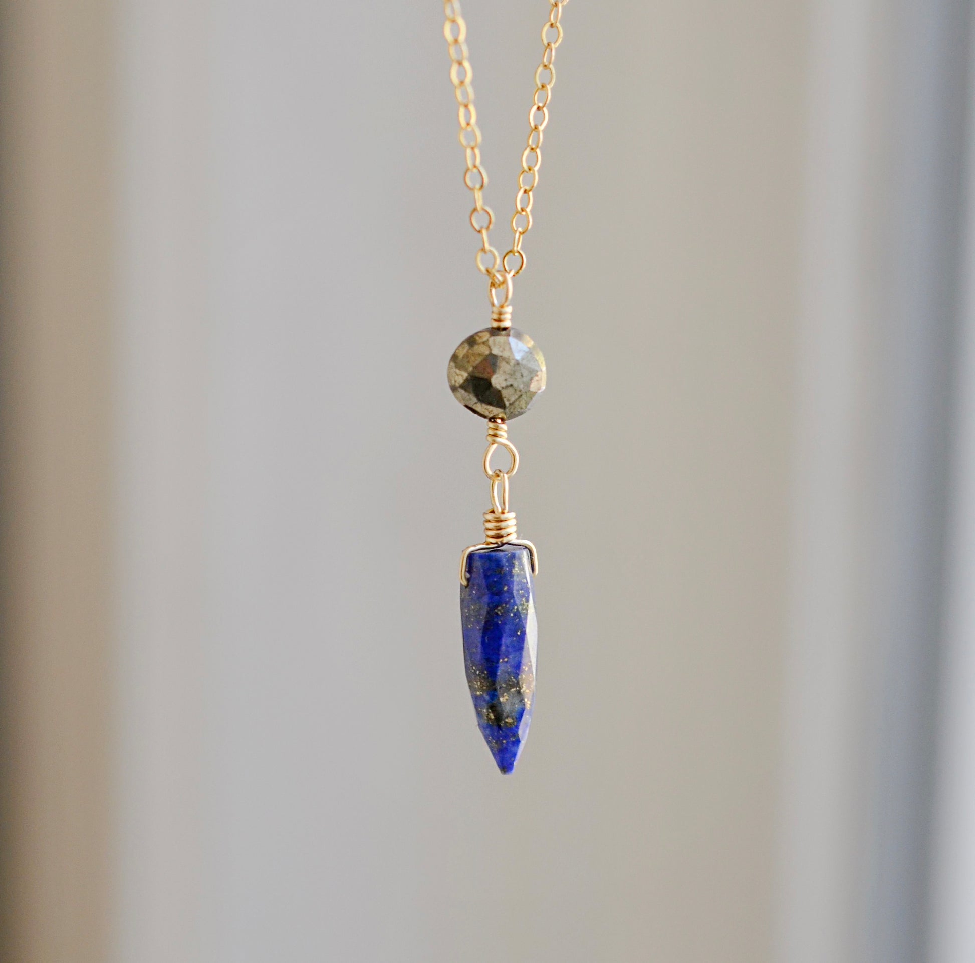 This necklace is handmade with natural pyrite and lapis lazuli suspended from a 14k gold filled or sterling silver chain.