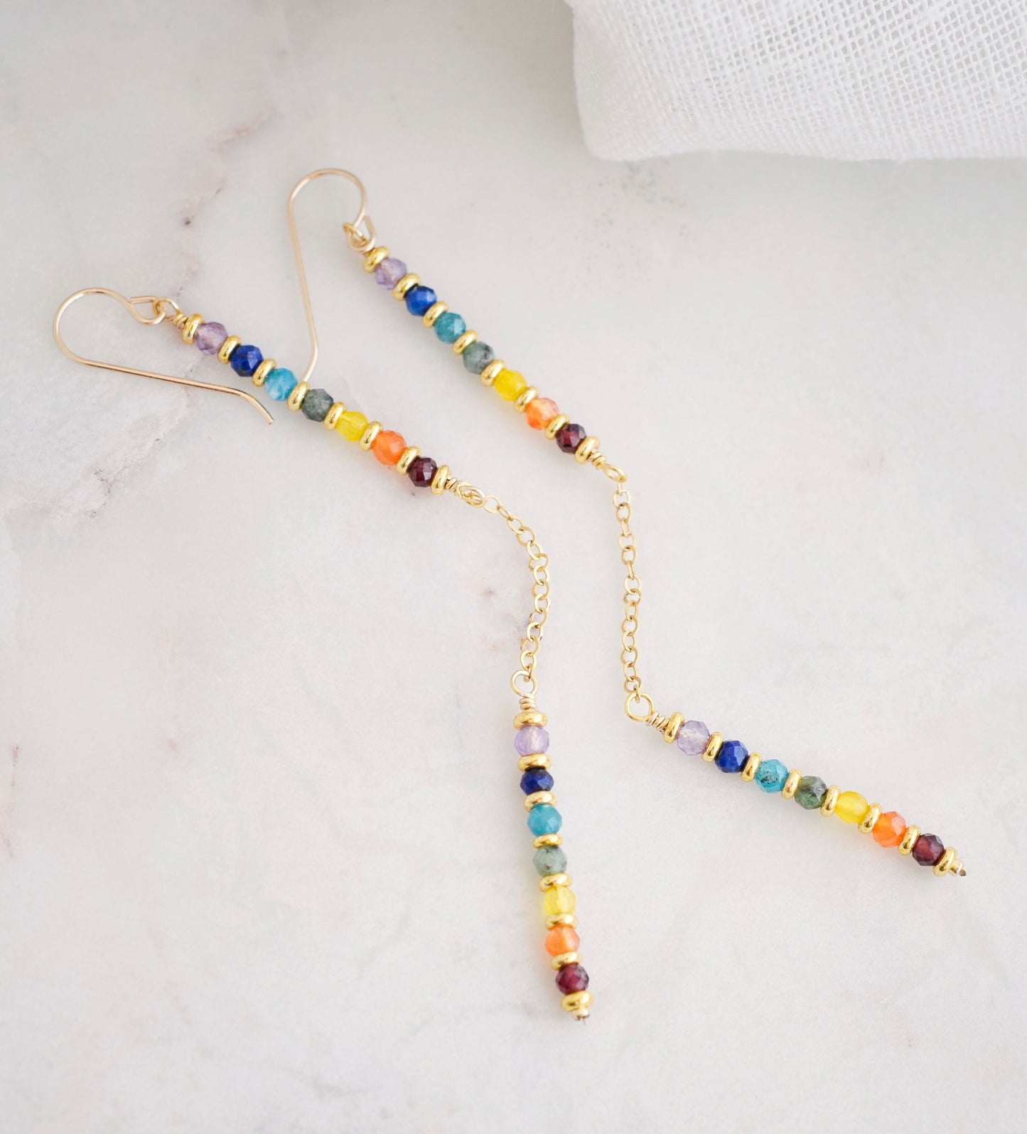 Two long, straight bars of crystals arranged in a rainbow pattern separated by a dainty chain. The gold style is shown. 