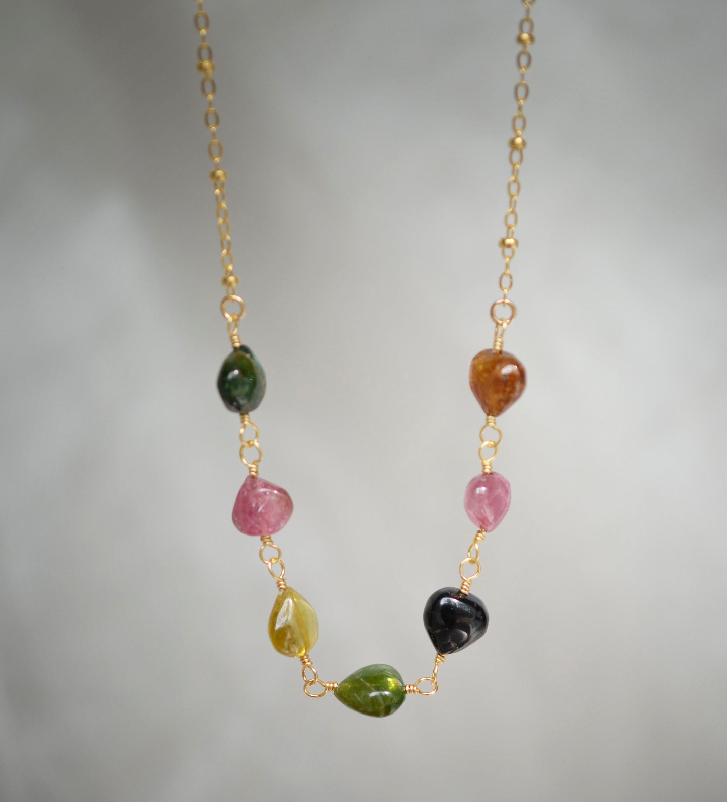 Multi color Tourmaline drops chain necklace. Shown in gold. Stone colors include: pink, green, black, yellow, or brown.