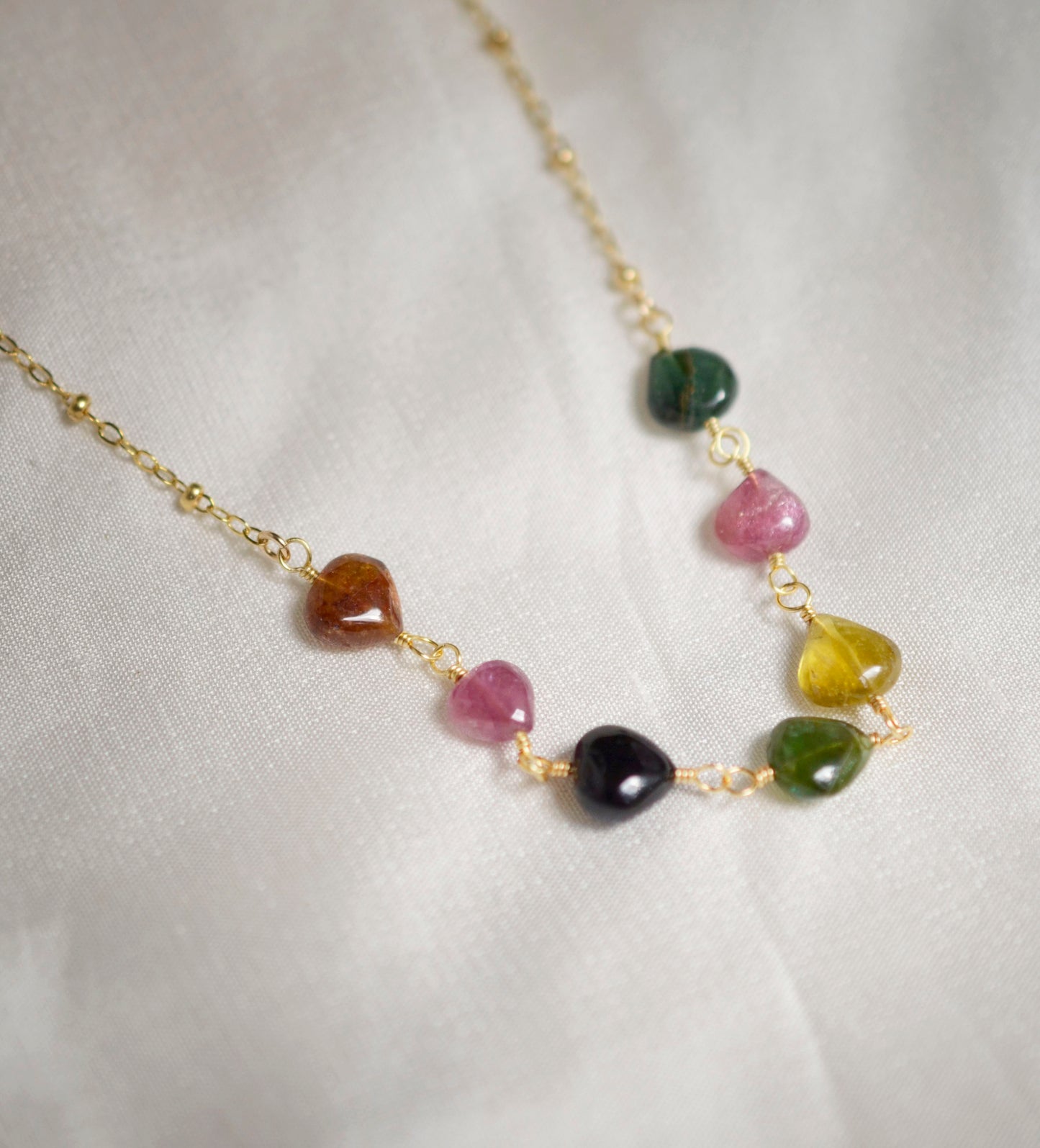 Multi color Tourmaline drops chain necklace. Shown in gold. Stone colors include: pink, green, black, yellow, or brown.
