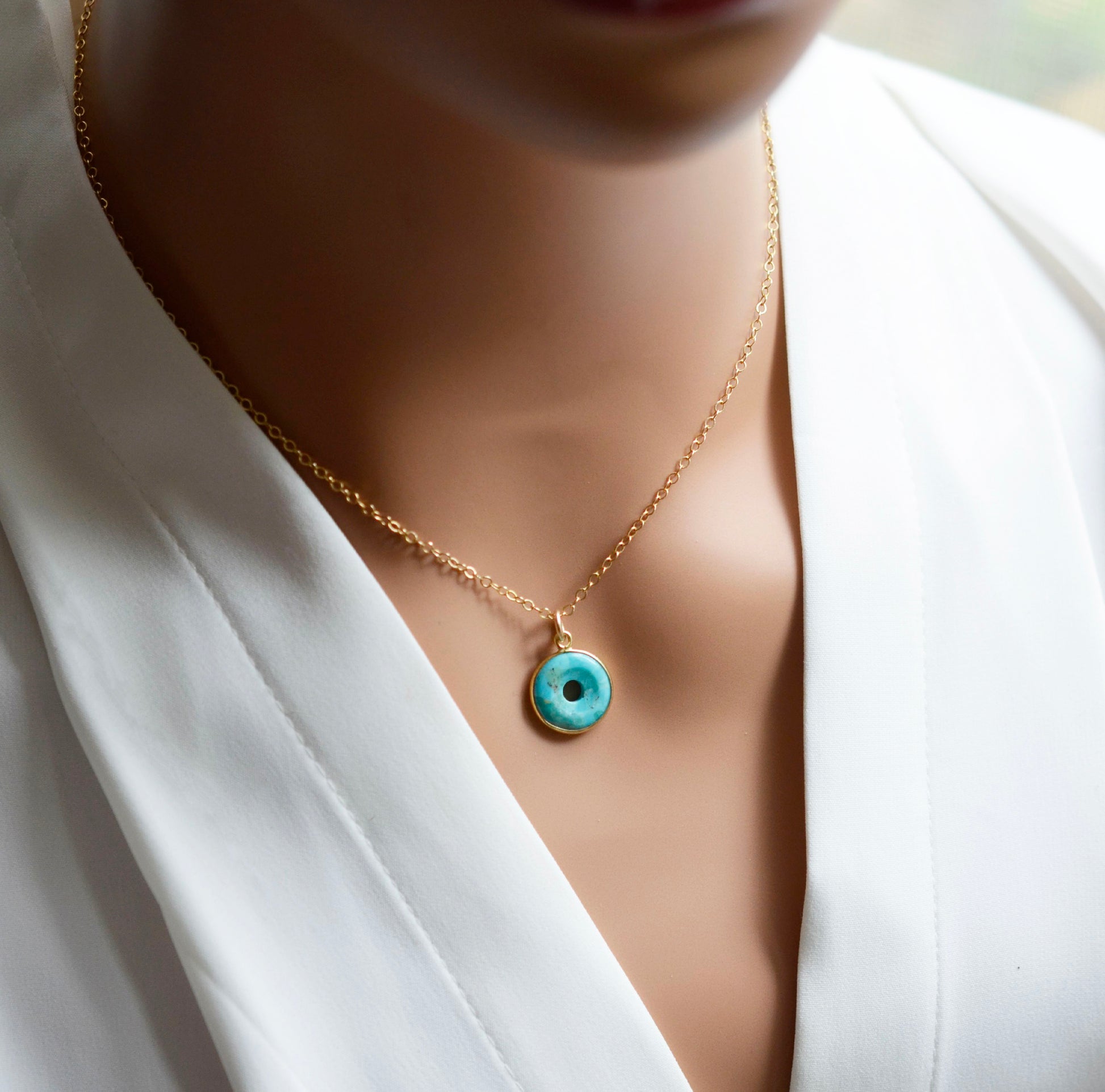 This necklace is handmade with a turquoise stone cut in a doughnut shape then suspended from a 14k gold filled chain. Also available in sterling silver.