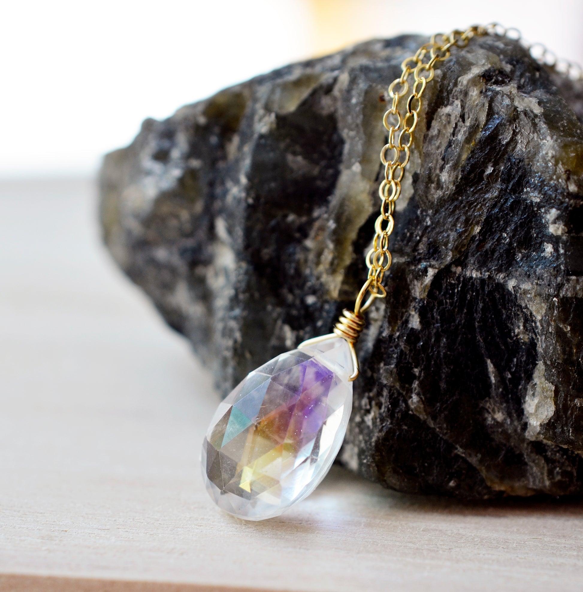 Rainbow hues shown within the Mystic Topaz. The gemstone is a faceted teardrop shape. The 14k gold filled style is shown.