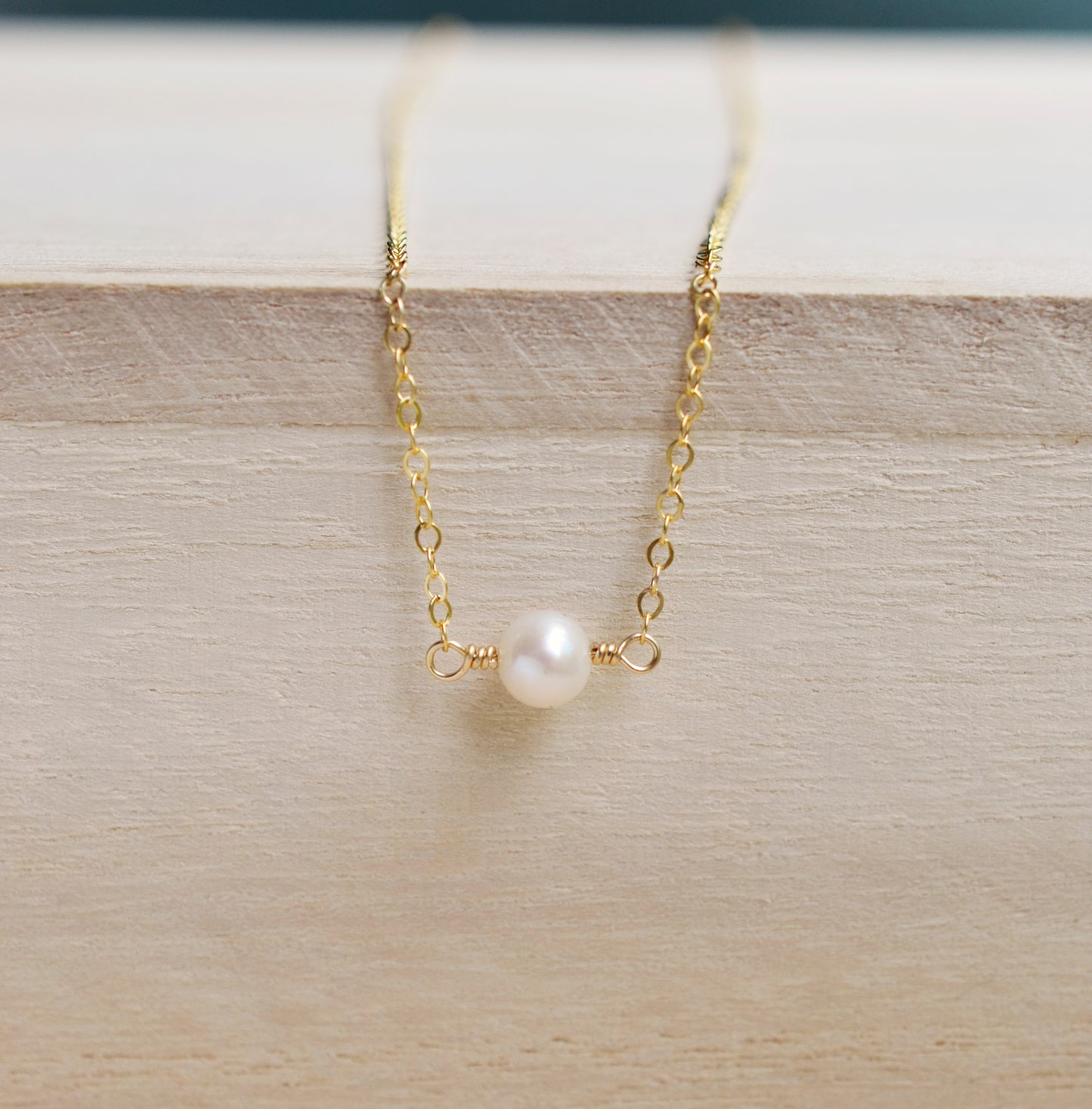 Single round white freshwater pearl necklace on a 14k gold filled chain.
