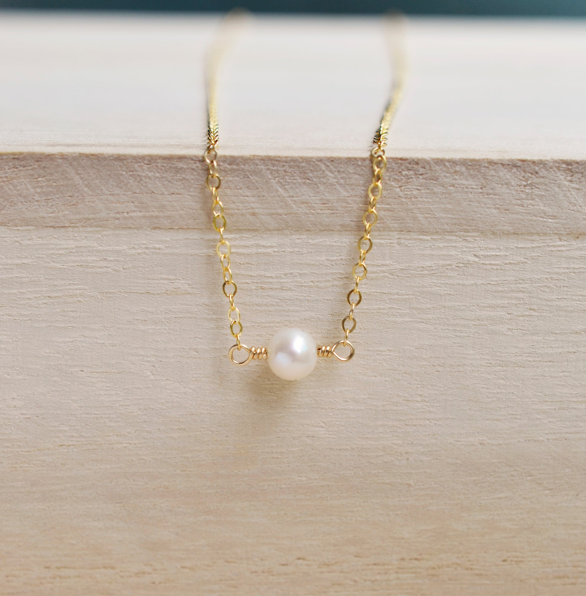 Single round white freshwater pearl necklace on a 14k gold filled chain.