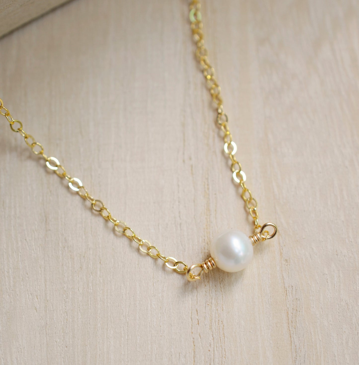 Single round white freshwater pearl necklace on a 14k gold filled chain.