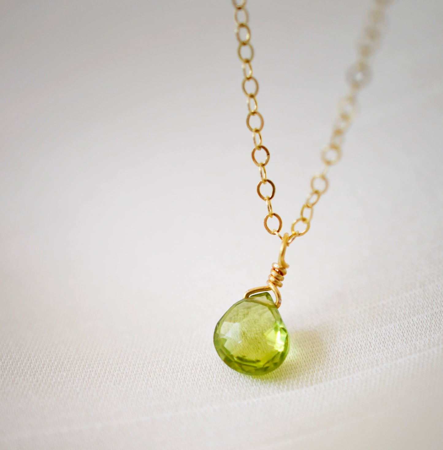 Natural green Peridot faceted teardrop suspended from a 14k gold filled cable chain.