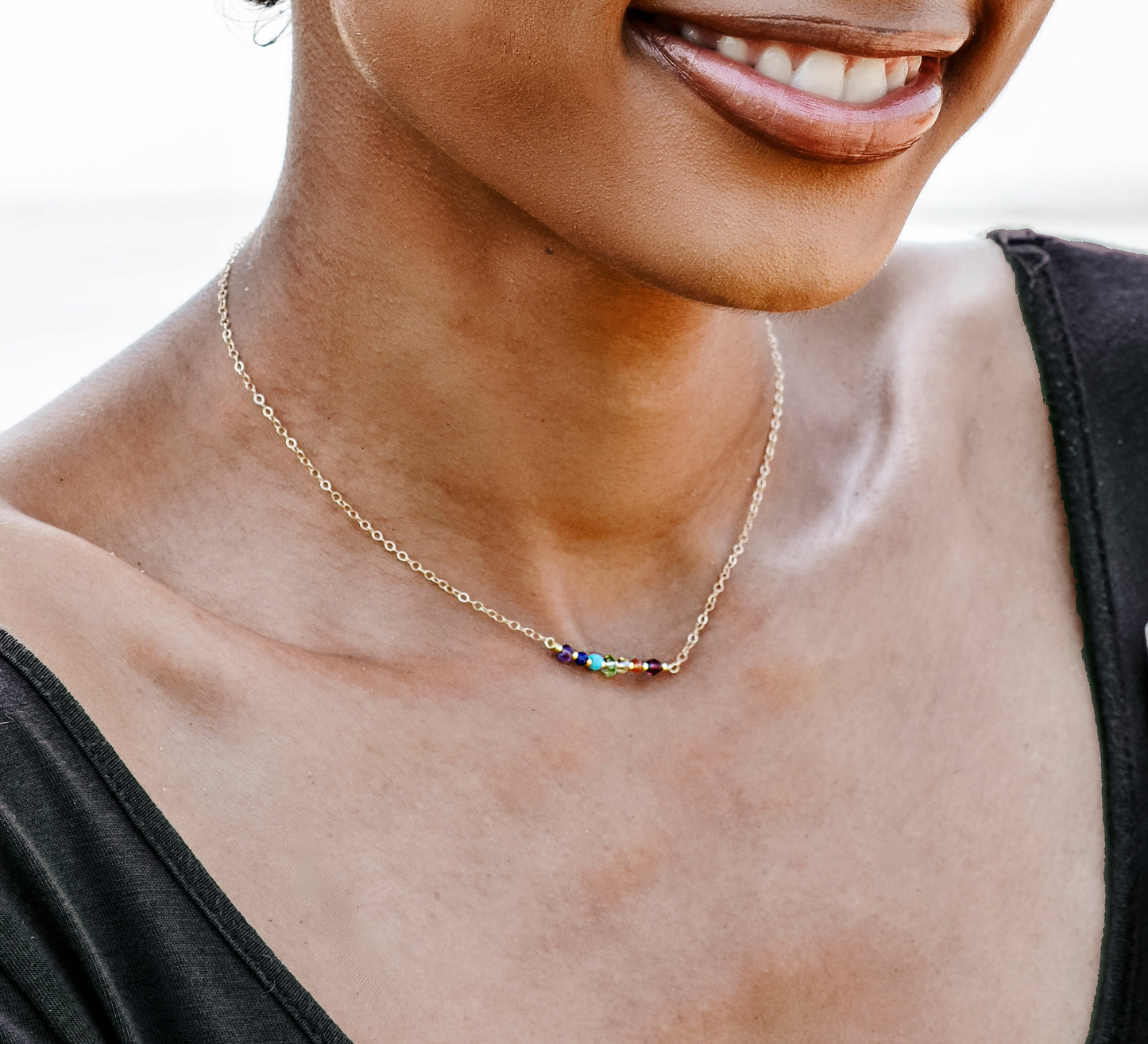 Modeled image. Handmade real gemstone chakra necklace. Stones include: garnet, carnelian, CZ, peridot, turquoise, lapis lazuli, and amethyst.