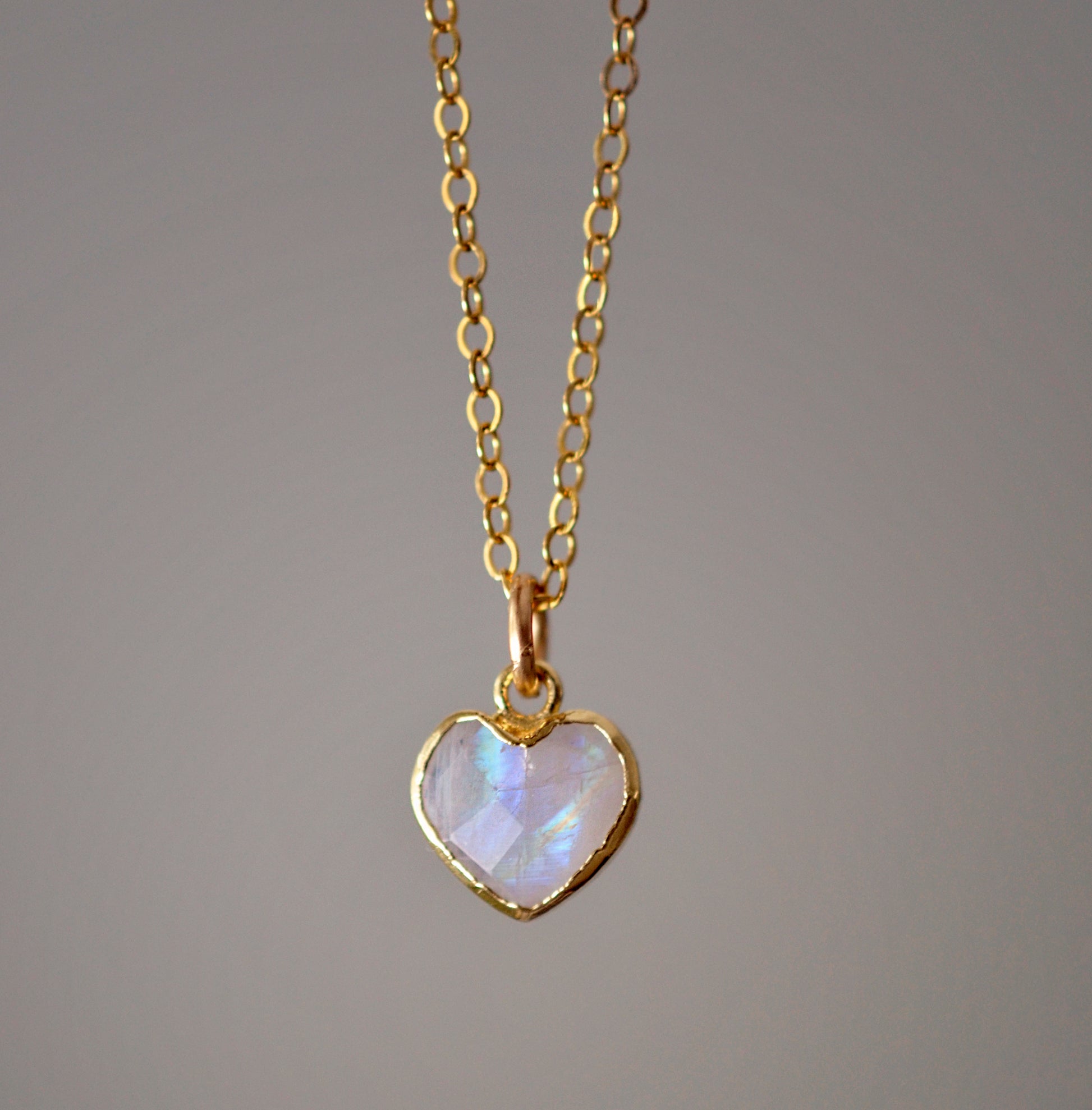 Natural rainbow moonstone heart pendant set onto a sterling silver or gold filled chain. Small stone heart pendant.