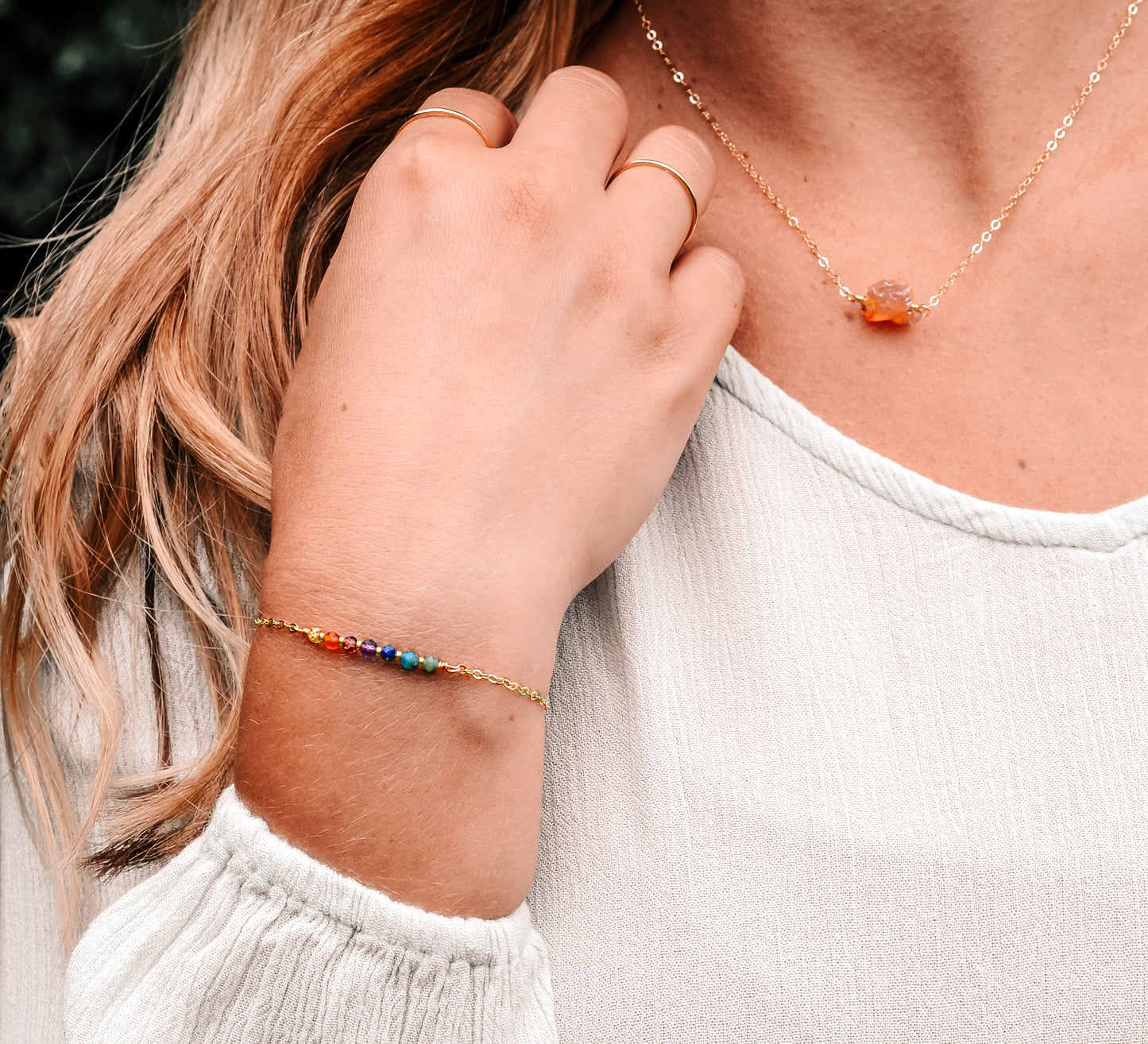 Handmade gemstone bracelet featuring CZ, garnet, amethyst, lapis lazuli, apatite, and emerald crystals arranged on a short bar. Available in gold filled or sterling silver.