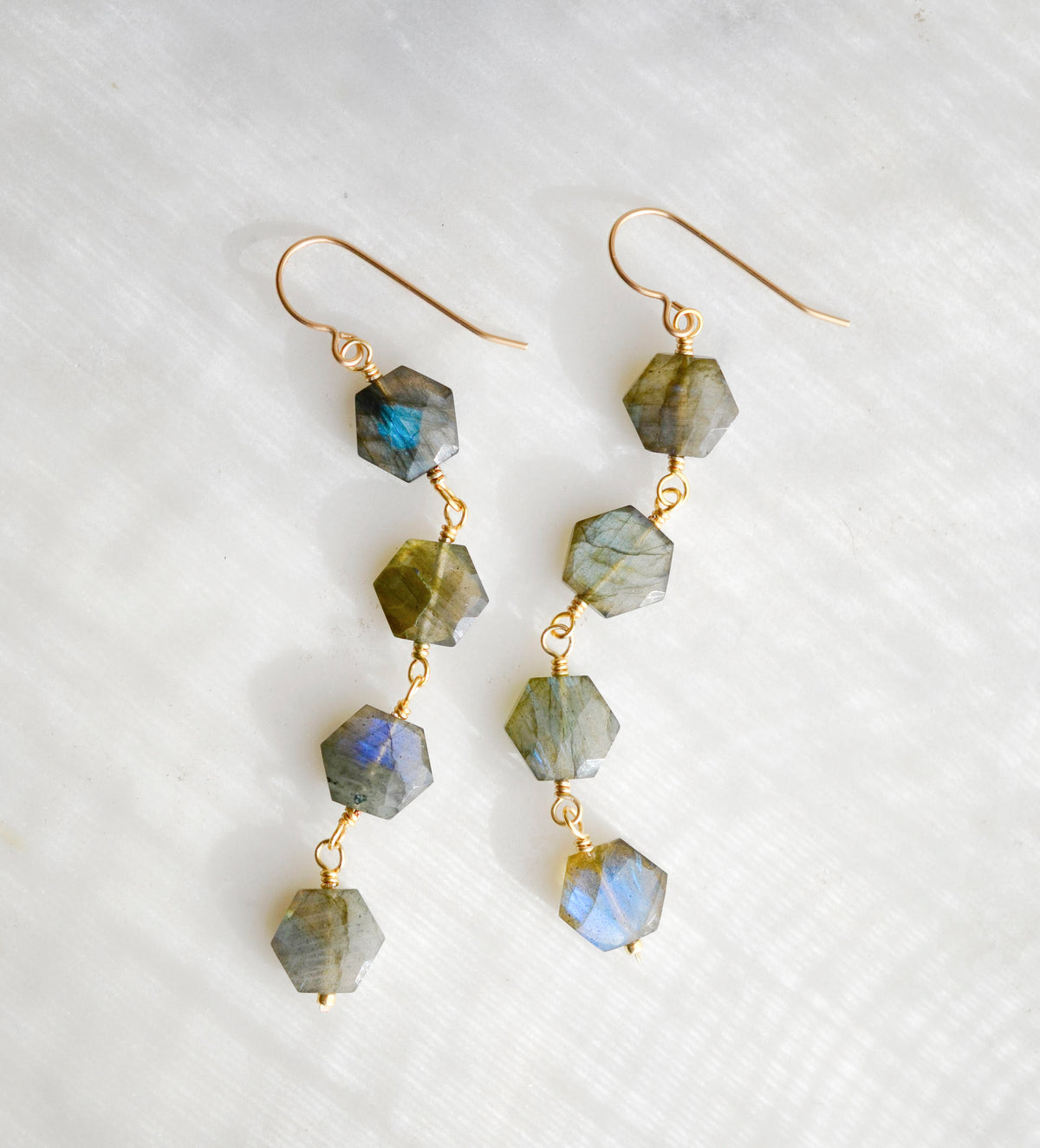 Long labradorite earrings designed for those who love a statement. These earrings feature four hexagonal gemstones with blue and green flash dangling in a straight line. Available in sterling silver or 14k gold filled.