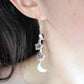 Three natural purple amethyst gemstone stars dangle atop rainbow moonstone crescent moons in these earrings. Shown in sterling silver. Modeled image.