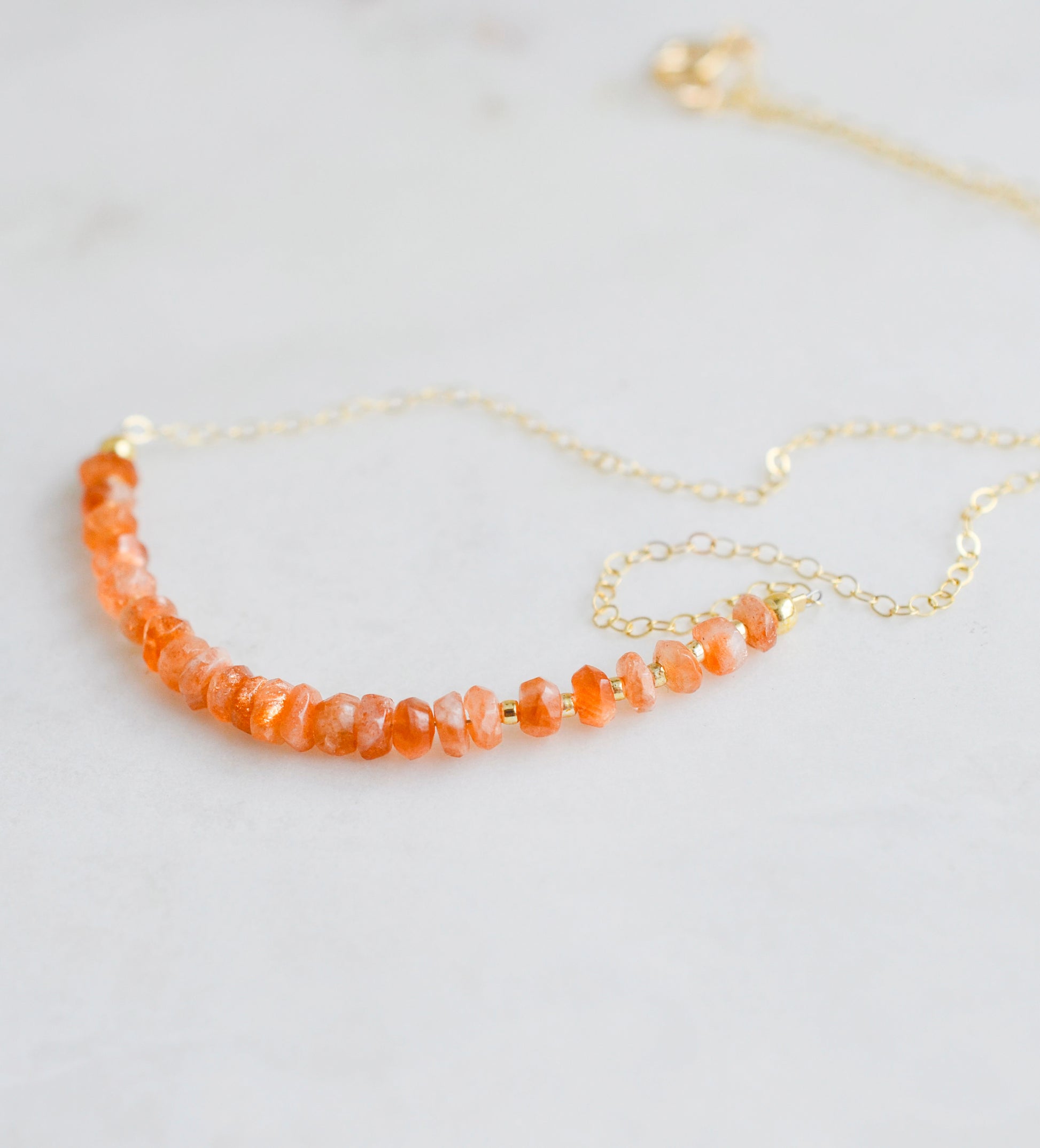 Close up of the faceted sunstone crystals set onto a gold filled necklace chain. 