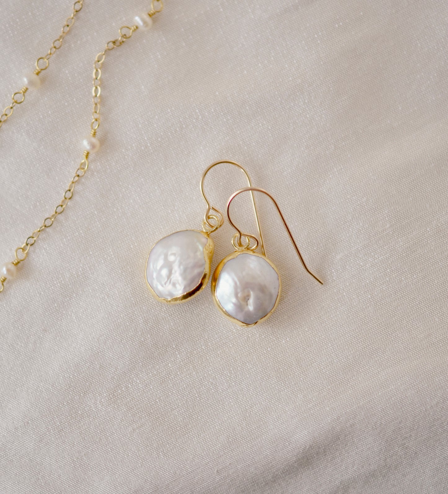 Natural white freshwater pearl dangle earring. The pearl is set in 22k gold electroplate and suspended from 14k gold filled earring hooks.