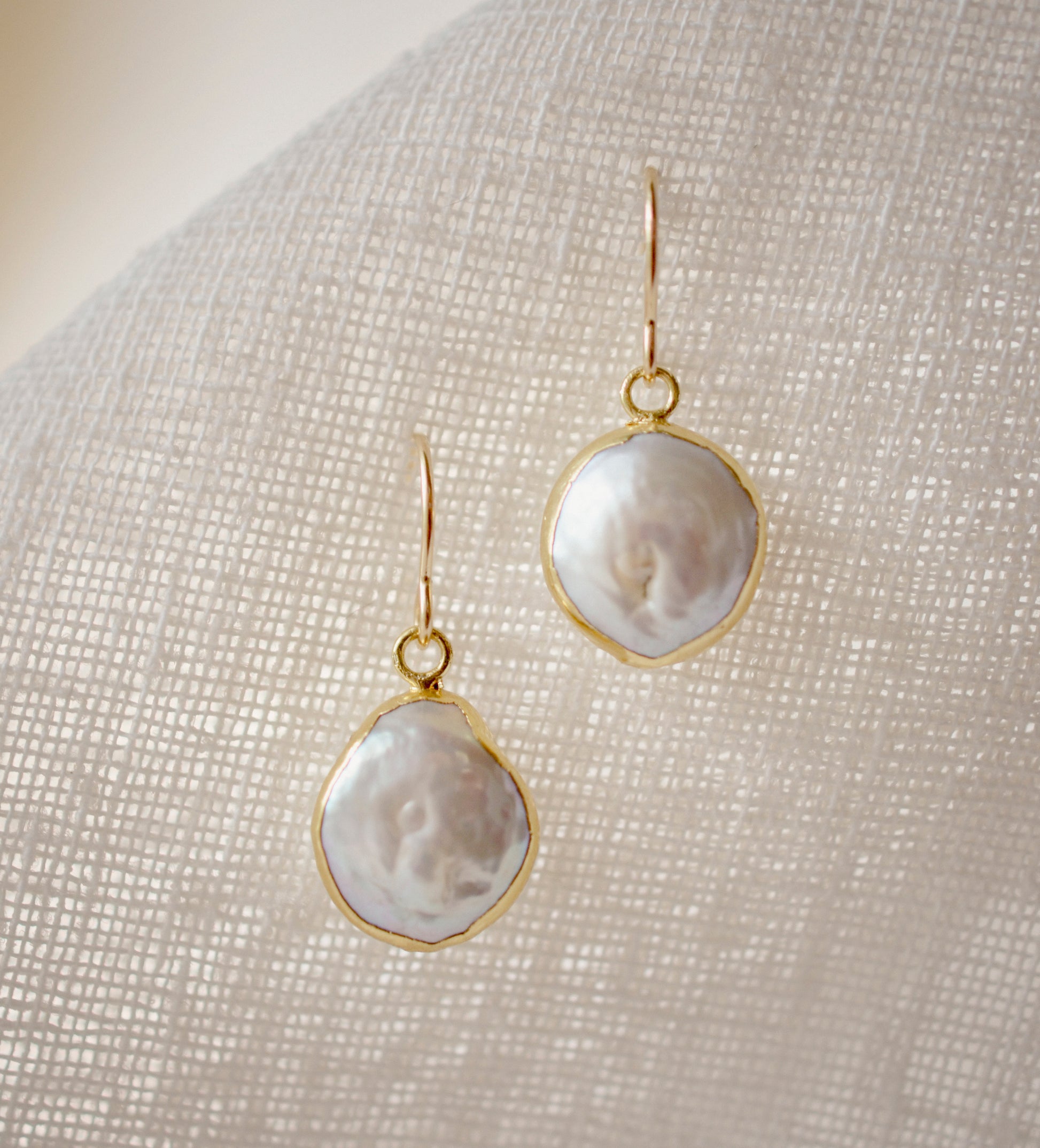 Natural white freshwater pearl dangle earring. The pearl is set in 22k gold electroplate and suspended from 14k gold filled earwires. 