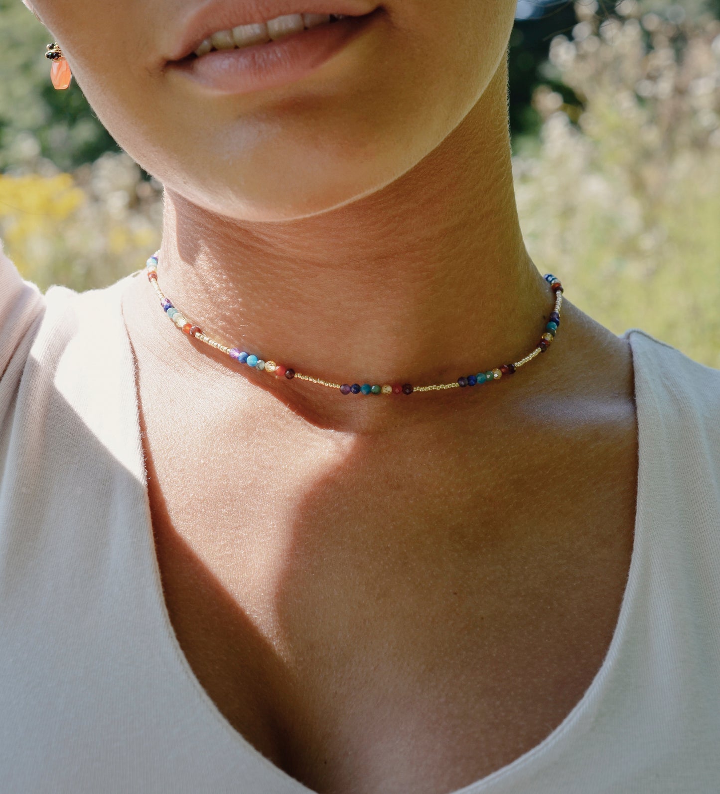 Tiny stones arranged in the order of the seven chakras or rainbow colors. Colors include: purple, blue, aqua, green, yellow, orange, and red. Modeled image.