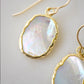 Close up of the shifting colors in these natural white mother of pearl dangle earrings.