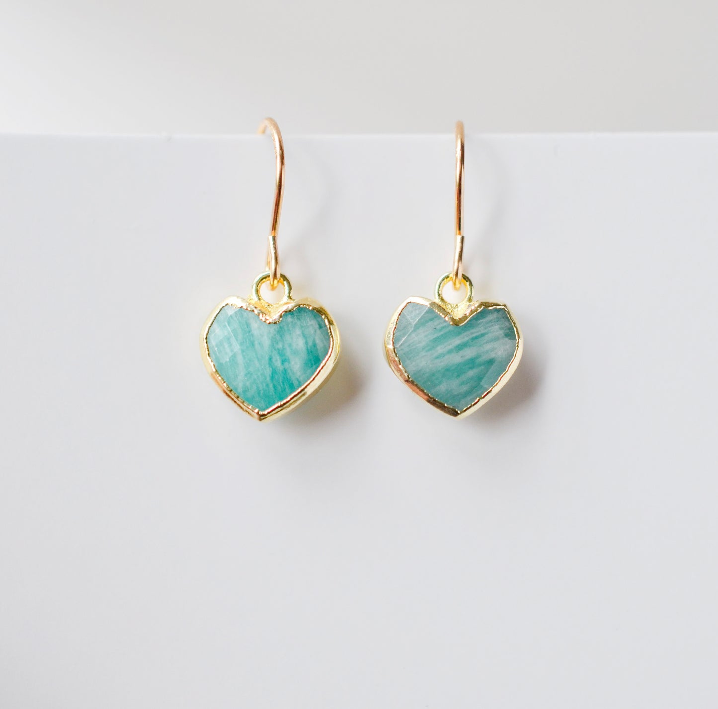 Aqua blue Amazonite gemstone heart earrings in gold. Modeled image. Natural Stones.