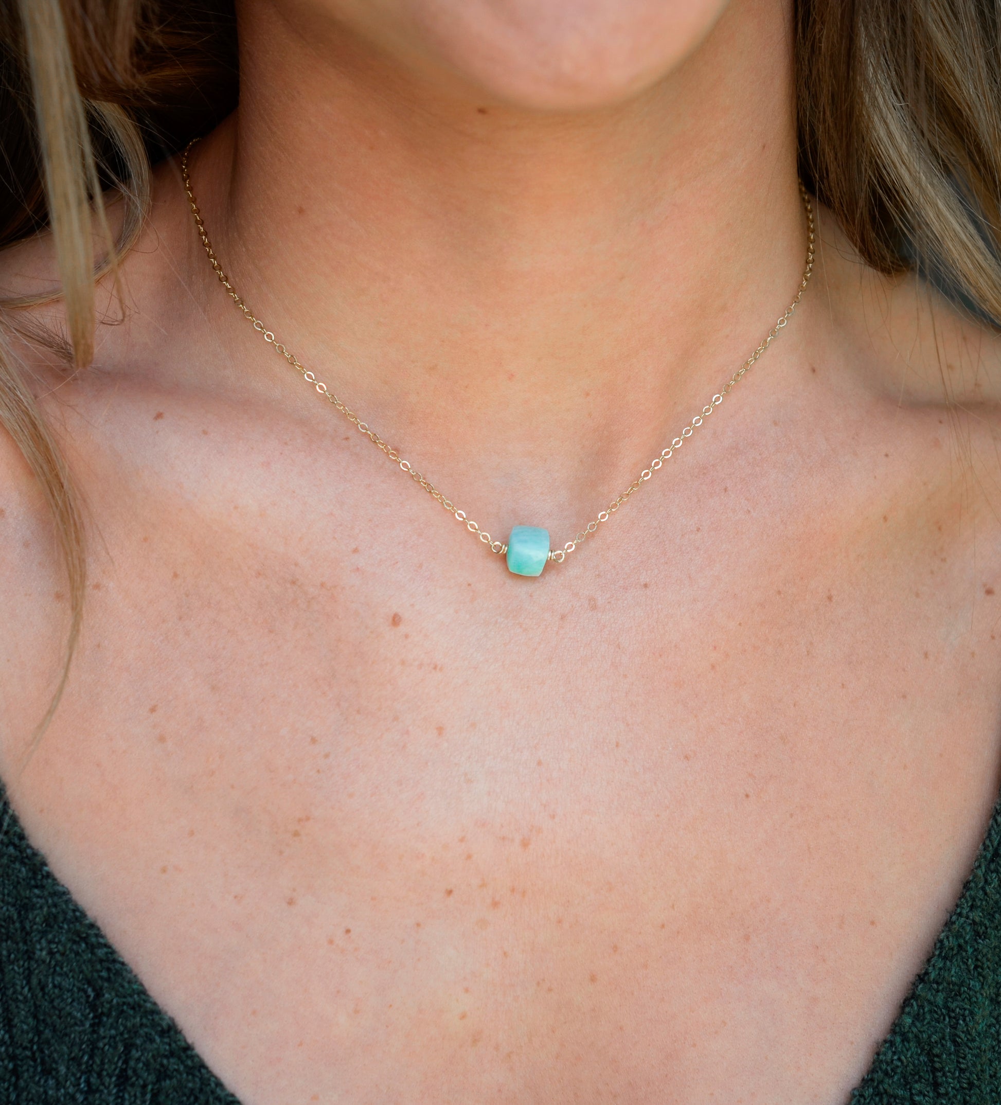 Genuine aqua blue Amazonite gemstone cut into a faceted cube and suspended on a gold filled cable chain. Modeled Image.