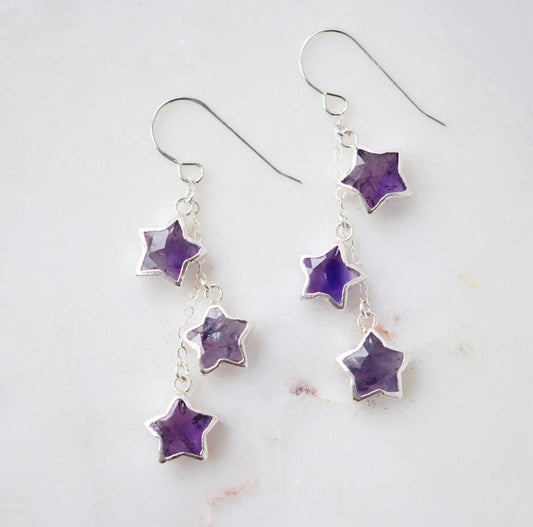 Sterling silver celestial amethyst star earring jewelry. Each earring features three purple amethyst stars dangling from a sterling silver chain.