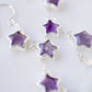 Three natural purple amethyst gemstone stars dangle atop rainbow moonstone crescent moons in these earrings. Shown in sterling silver. Close up.