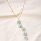 Genuine aqua blue Apatite gemstones set onto a beaded gold chain. The stones are flat faceted ovals and vary in aqua hues.