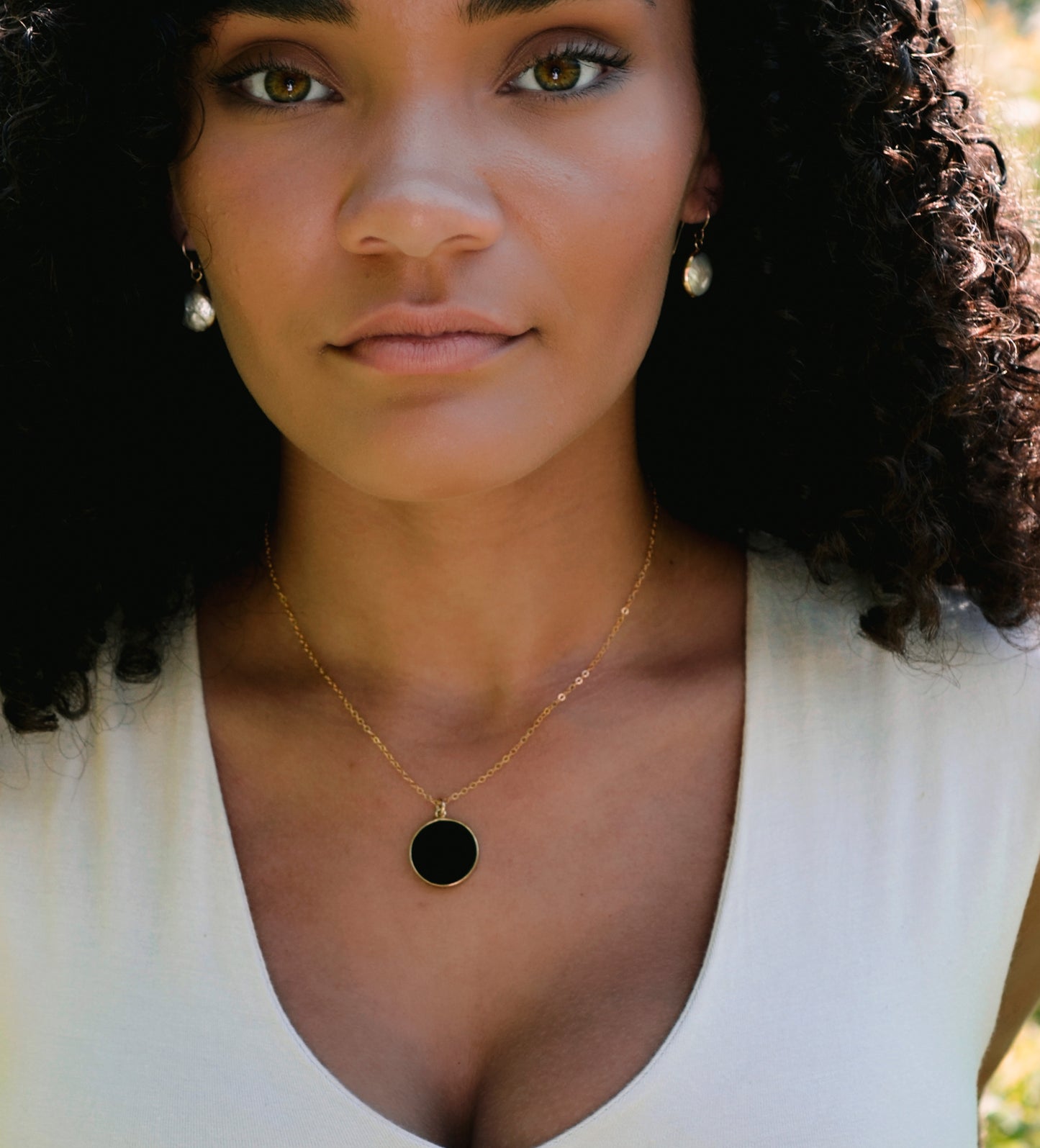 Smooth Polished Black Onyx Circle Pendant on Simple Gold Chain. Modeled Image.