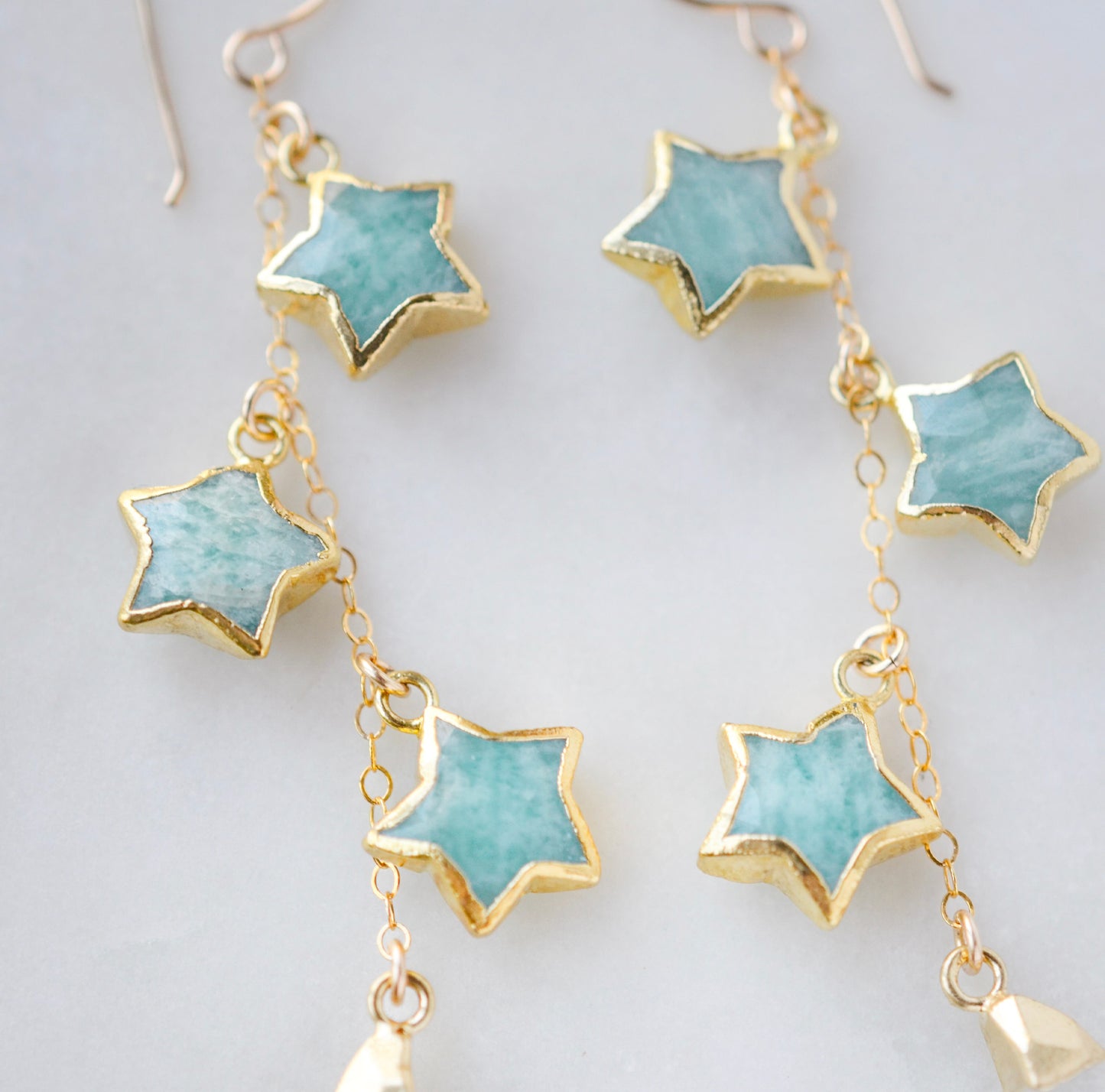 Blue celestial, amazonite star earrings in gold with rainbow moonstone crescents. Each earring has three gemstone stars and one moon dangling from it.