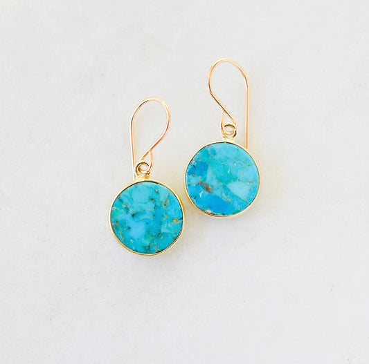 Real turquoise gemstones set in gold vermeil bezels and suspended from 14k gold filled ear wires. These handmade earrings feature smooth polished round stones. Artisan jewelry from Connecticut by GEMNIA.