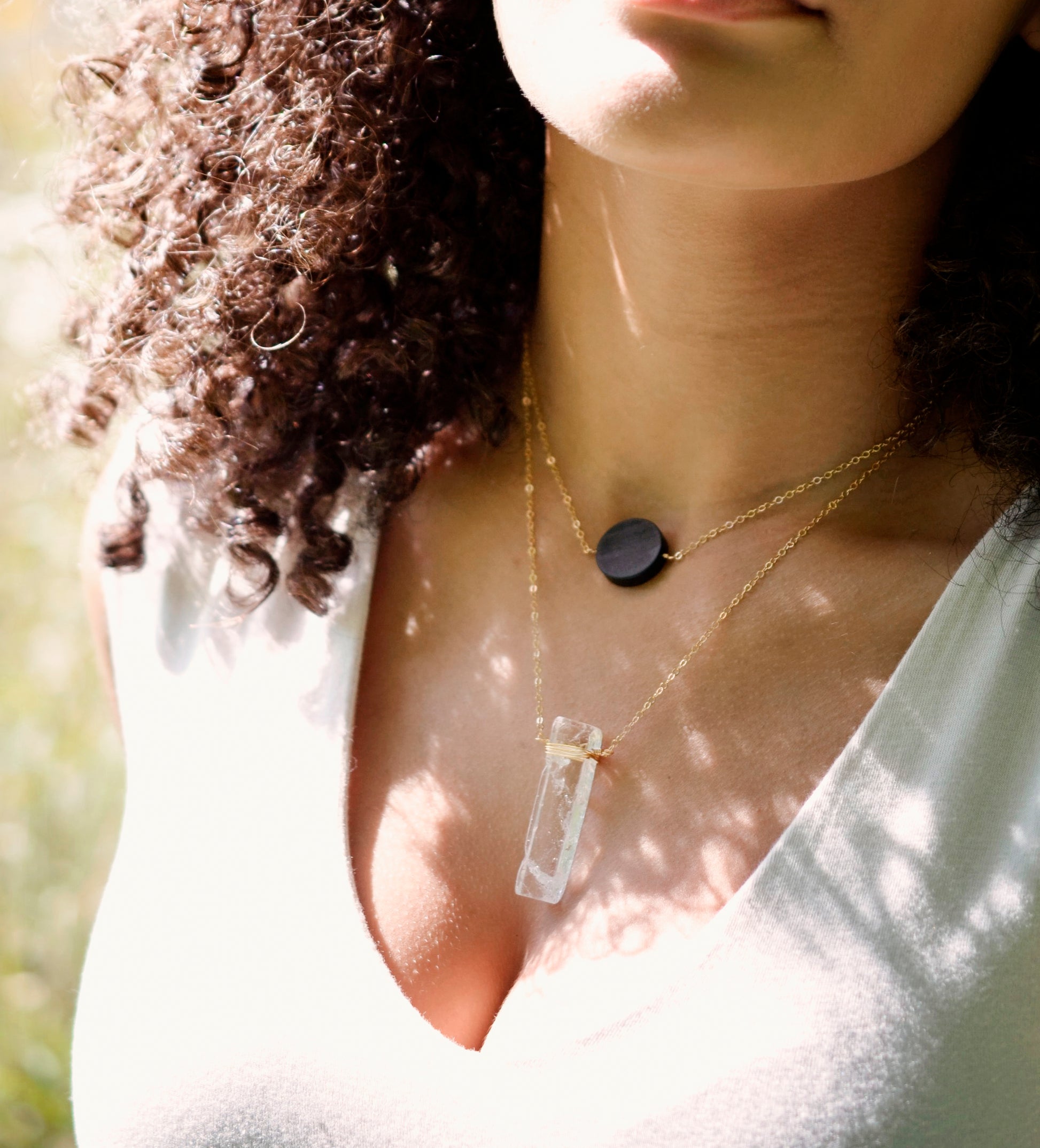 Rectangular shaped natural clear crystal Quartz gemstone set into a 14k gold filled chain. Modeled image. Shown with a black Onyx pendant.
