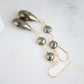 Close up of faceted pyrite coin gemstones. Long teardrop earrings shown in 14k gold filled.