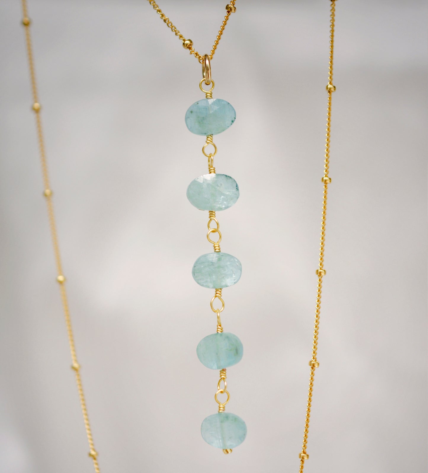 Genuine aqua blue Apatite gemstones set onto a beaded gold chain.