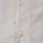Genuine white freshwater pearls of varying sizes alter on this chain necklace. The gold style is shown.