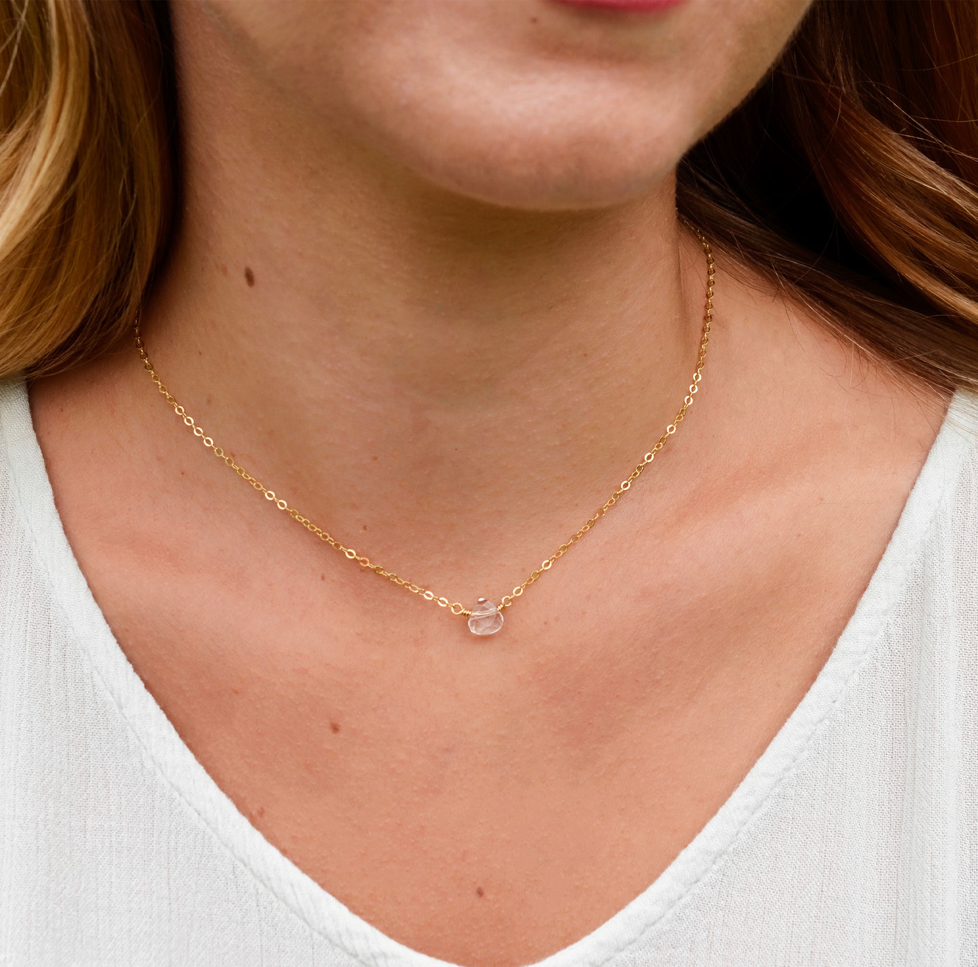 A clear, natural crystal quartz faceted teardrop set onto a 14k gold filled chain. Modeled image.