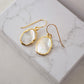 Natural oval shaped white mother of pearl oval shaped dangles suspended from 14k gold filled earwires. These minimalist earrings are handmade in Connecticut. The edges are dipped in 24k gold.
