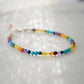Tiny gemstone beaded bracelet in rainbow colors. Colors include: blue, green, yellow, red, orange, and purple. This bracelet is handmade in Connecticut by Gemnia Jewelry.
