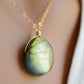 Labradorite oval pendant with yellow-green flash. The chain in 14k gold filled. Close up image.