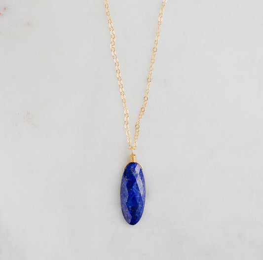 A handmade natural genuine blue lapis lazuli gemstone pendant on a dainty 14k gold filled chain. This necklace is made in Connecticut by Gemnia Jewelry.