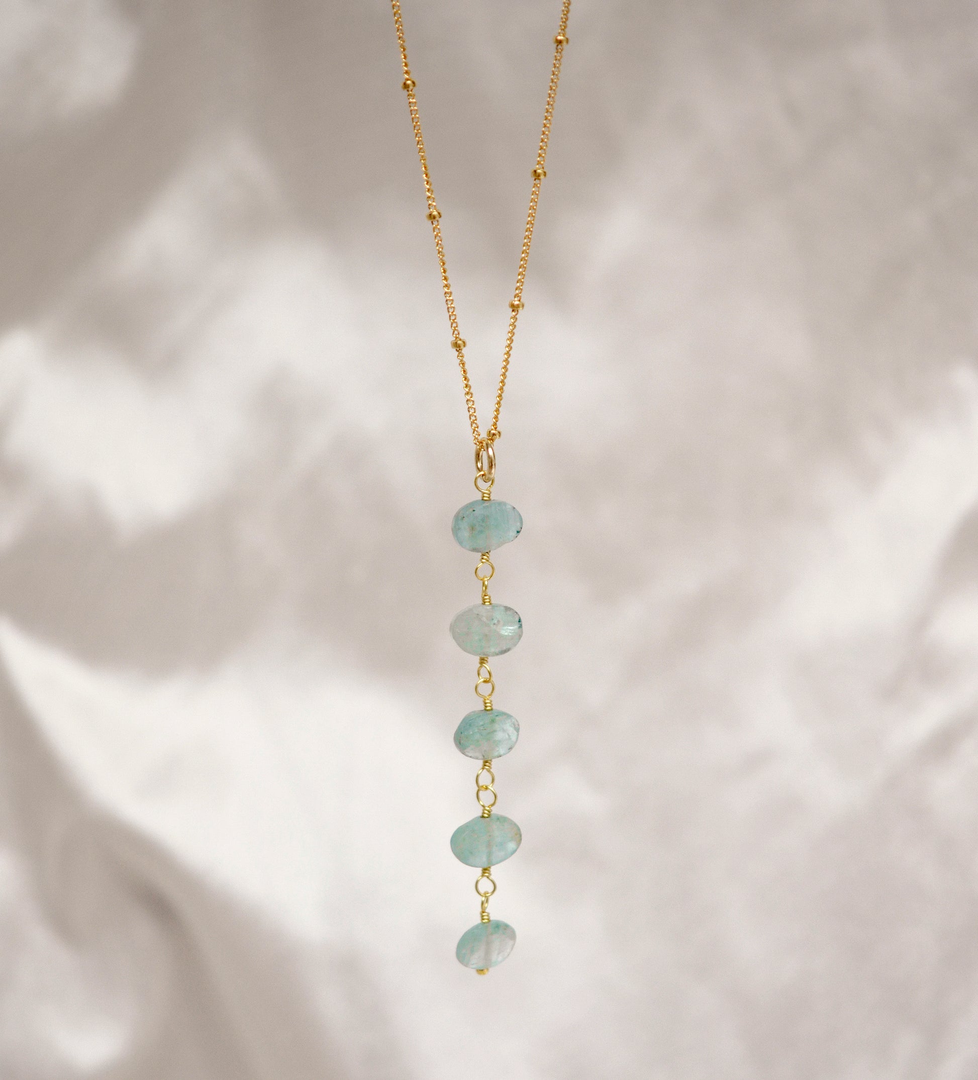 Genuine aqua blue Apatite gemstones set onto a beaded gold chain.