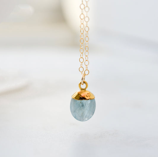 Stone pendant with a dainty aquamarine gemstone set on a 14k gold filled chain. The necklace is handmade in Connecticut by Gemnia Jewelry.